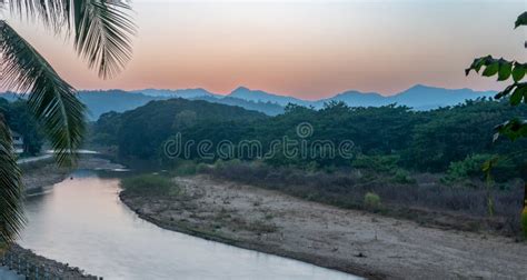 Sunset Over The Thai Burmese Mountains With River And Palm Tree Stock