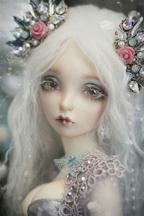 A Doll With Long White Hair Wearing A Tiara And Pearls On Its Head