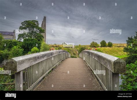 Wooden Bridge Over River Boyne With A View On Ruined Tower Of St Marys