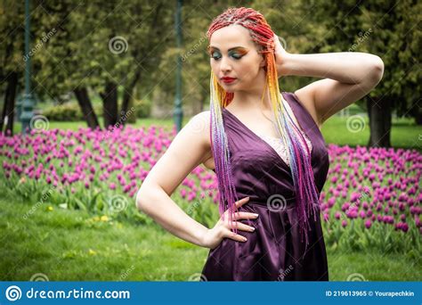 A Beautiful Girl With Expressive Makeup And African Braids In A Bright Purple Dress Walks In A
