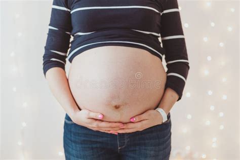 Close Up Of Pregnant Woman`s Big Hairy Belly On Bright Bokeh Lights