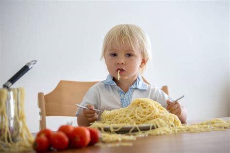 Baby Boy Eating Pasta With His Hand Stock Photos Pictures And Royalty