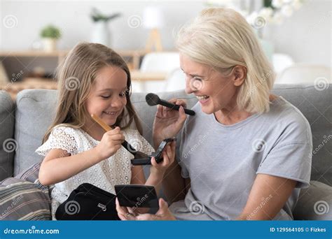 Happy Grandma And Granddaughter Have Fun Doing Make Up Stock Image