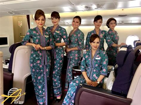 The Cabin Attendants Are All Dressed In Green And Pink Floral Outfits Posing For A Photo