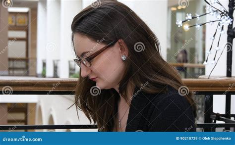 Portrait Of Young Beautiful Girl In Glasses Working In Shopping Mall With Her Laptop She Is