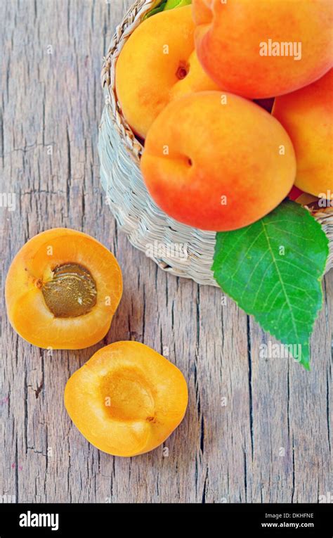 Apricot Fruits With Green Leaf And Cut Isolated On Wooden Background