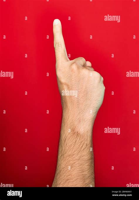 Beautiful Hand Of Man Raised Up Showing One Finger Over Isolated Red