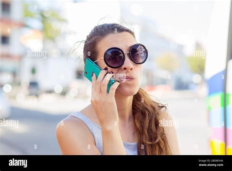 closeup portrait upset sad skeptical unhappy serious woman talking on phone displeased with