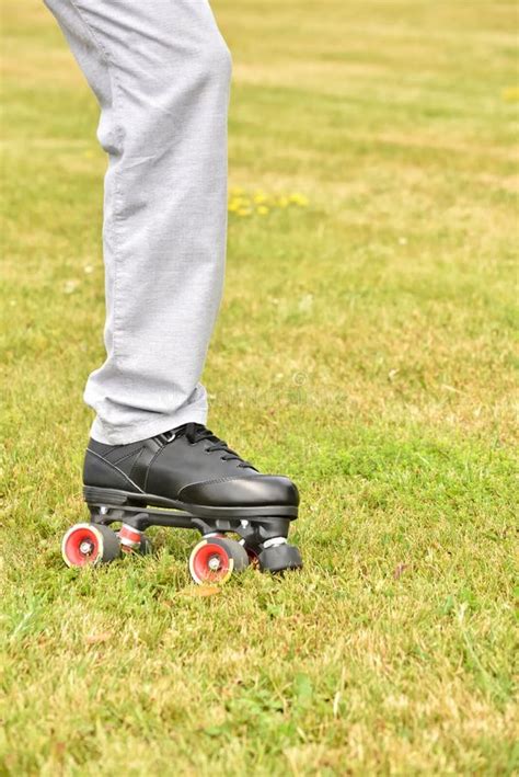Male Leg In Roller Skates On The Background Of A Grass Field Stock