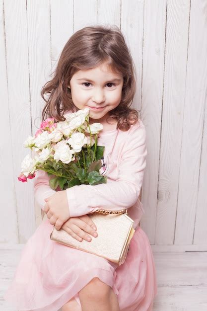 Premium Photo Little Pretty Girl In Pink Holds The Bouquet Of Roses Little Lady Sitting On A