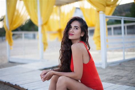 giovane bella donna in bikini rosso con la posa lunga dei capelli ricci fotografia stock