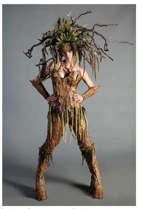 A Woman Dressed As A Tree Man With Branches On Her Head