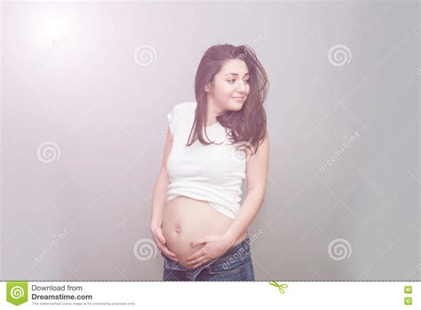 Pregnant Girl In Unbuttoned Jeans And White Tshirt Naked Belly Stock