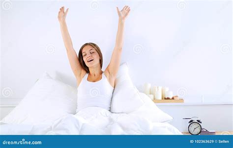 An Attractive Young Woman Stretching In Bed After Waking Up Stock