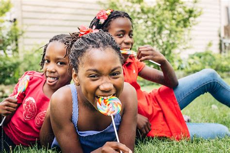 Three Black Girls With Lollipops Laughing By Stocksy Contributor