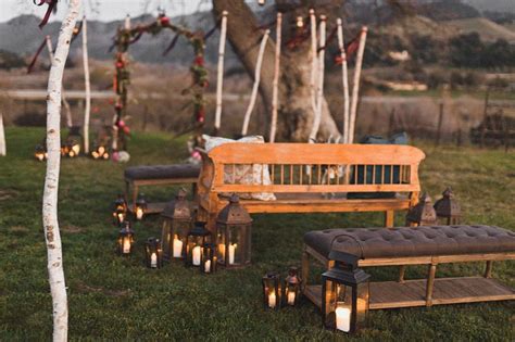 a wooden bench sitting next to a tree filled with candles