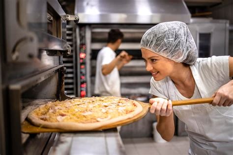 Premium Photo Female Chef In White Uniform And Hairnet Putting Pizza