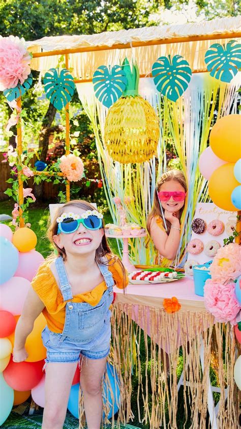 Two Girls Posing With A Tiki Bar Covered With Streamers And Balloons At