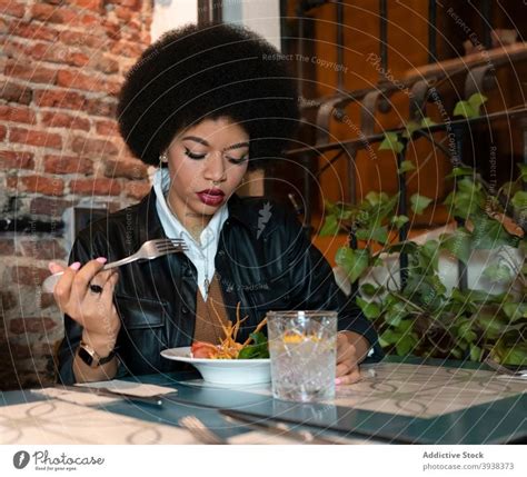 Young Black Woman Eating Salad In Restaurant A Royalty Free Stock