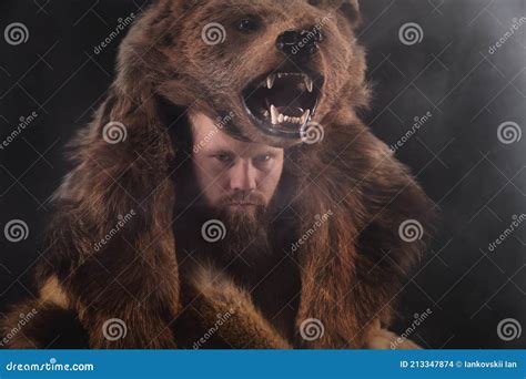 Low Key Portrait Of A Bearded War Shaman In Bearskin With An Ancient Ax