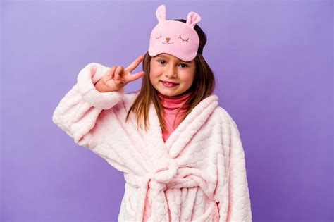 Niña Caucásica Vistiendo Pijama Aislado En La Pared Púrpura Que Muestra