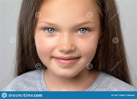 Portrait Of A Beautiful Smiling Girl With Blue Eyes With Light Brown Hair She Looks Into The