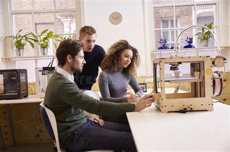 Two Designers Working With 3d Printer In Design Studio Stock Photo