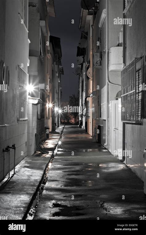 Looking Down A Long Dark Empty Back Alleyway After The Rain Stock Photo