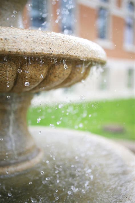 Close Up On Water Droplets Dripping Off Stone Fountain Stock Photo