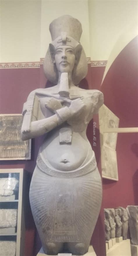 An Ancient Statue Is On Display In A Room With Red Walls And Other