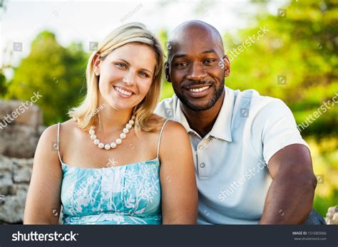 Stock Photo Portrait Of A Mixed Race Couple Sitting At The Park In