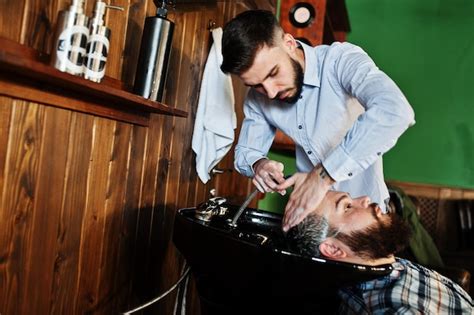 premium photo handsome bearded man at the barbershop barber at work washing head