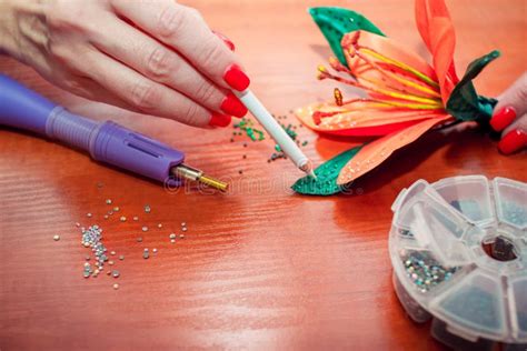 Close Up Woman`s Hands Decorating Artificial Lily Flower With Colorful