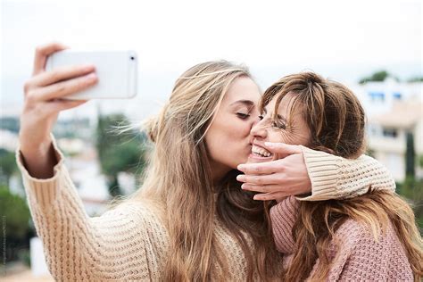 Woman Kissing Her Mother While Making Selfie By Stocksy Contributor Guille Faingold Stocksy