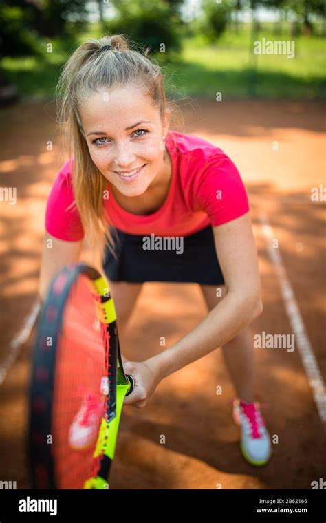 Pretty Young Woman Tennis Player Playing On A Clay Court Healthy