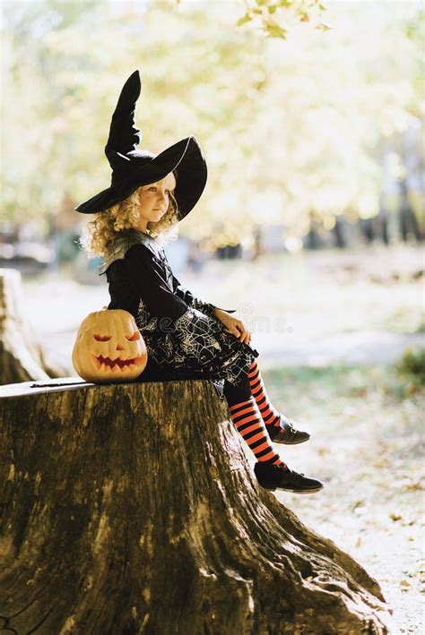 Little Girl In Witch Costume Celebrate Halloween Outdoor And Have Fun