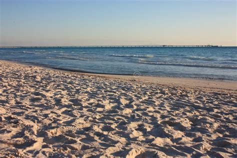 Sunset At The Sea In Front Of The Blue Water And White Sand Of The