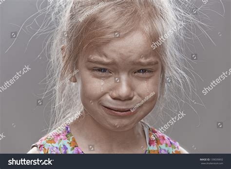 Beautiful Sad Little Girl Crying On Gray Background Stock Photo