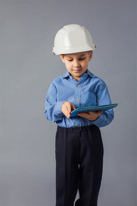 The Little Boy With Tablet Dressed In A Costume Of Engineer Stock Image