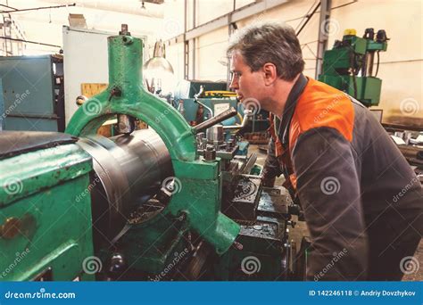 Turner Worker Manages The Metalworking Process Of Mechanical Cutting On