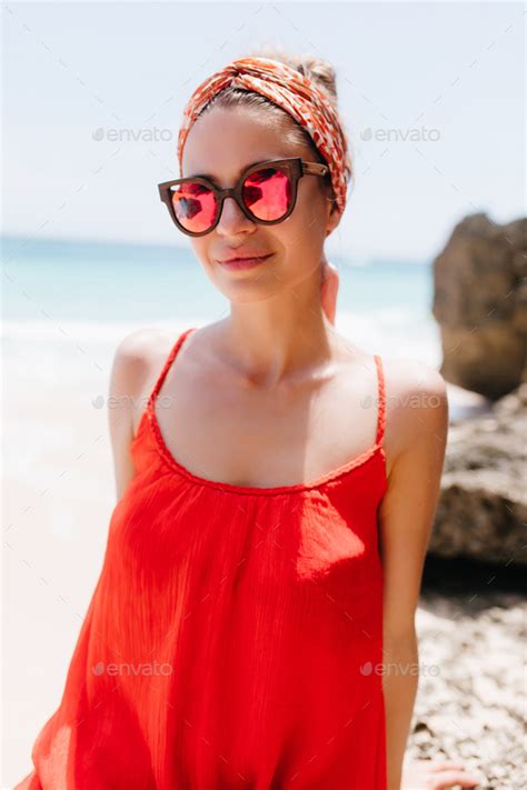 Good Looking Female Model Posing In Red Dress On Sea Background