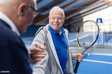 Two Senior Tennis Players Shaking Hands On Tennis Court High Res Stock