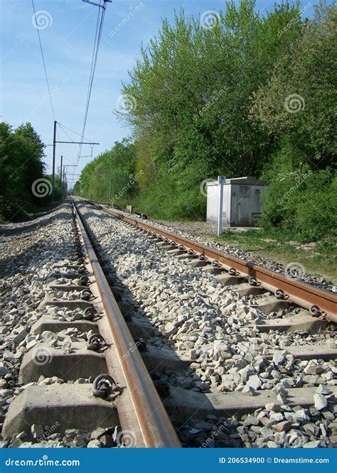 Some Railroad Tracks Leading To The Horizon With A Blue Sky Above Stock