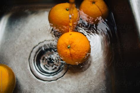Oranges Being Washed In Kitchen Sink At Home By Jessica Byrum
