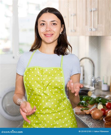 Positive Girl Housewife In Apron Standing At Home Kitchen Stock Image