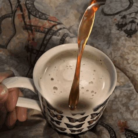 A Person Pouring Liquid Into A Coffee Cup