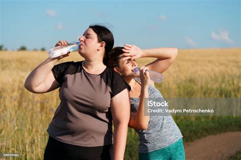Women Drink Water And Rest After Outdoor Jogging Stock Photo Download