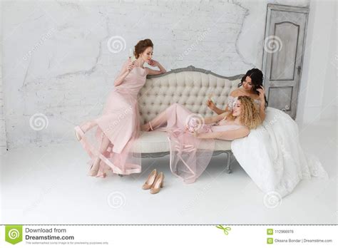 Brides Taking Selfie While Playing On Sofa And Drinking Champagne Stock