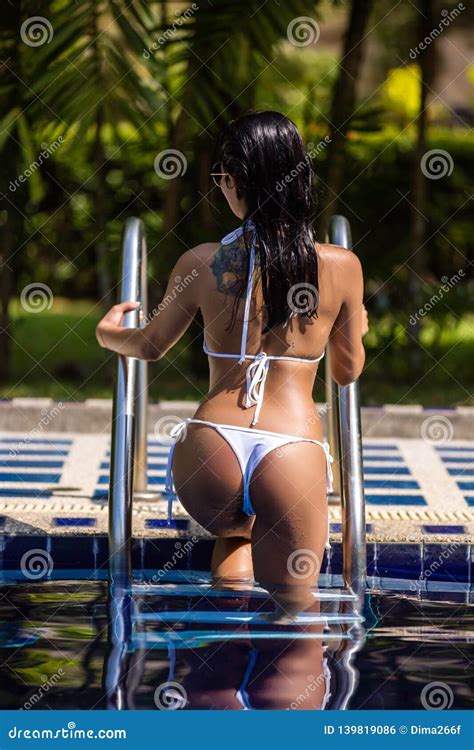 Asian Woman In The White Bikini Sun Tanned Skin Is Posing In The