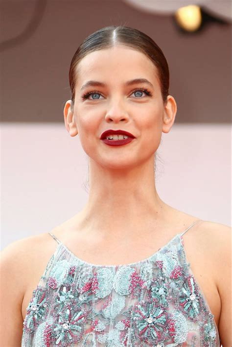 A Woman With Blue Eyes And Red Lipstick Is Posing For The Camera At An